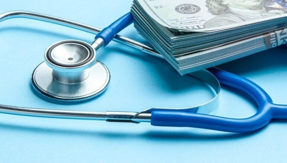 Stack of cash dollars and stethoscope on blue background the concept picture id1125842354